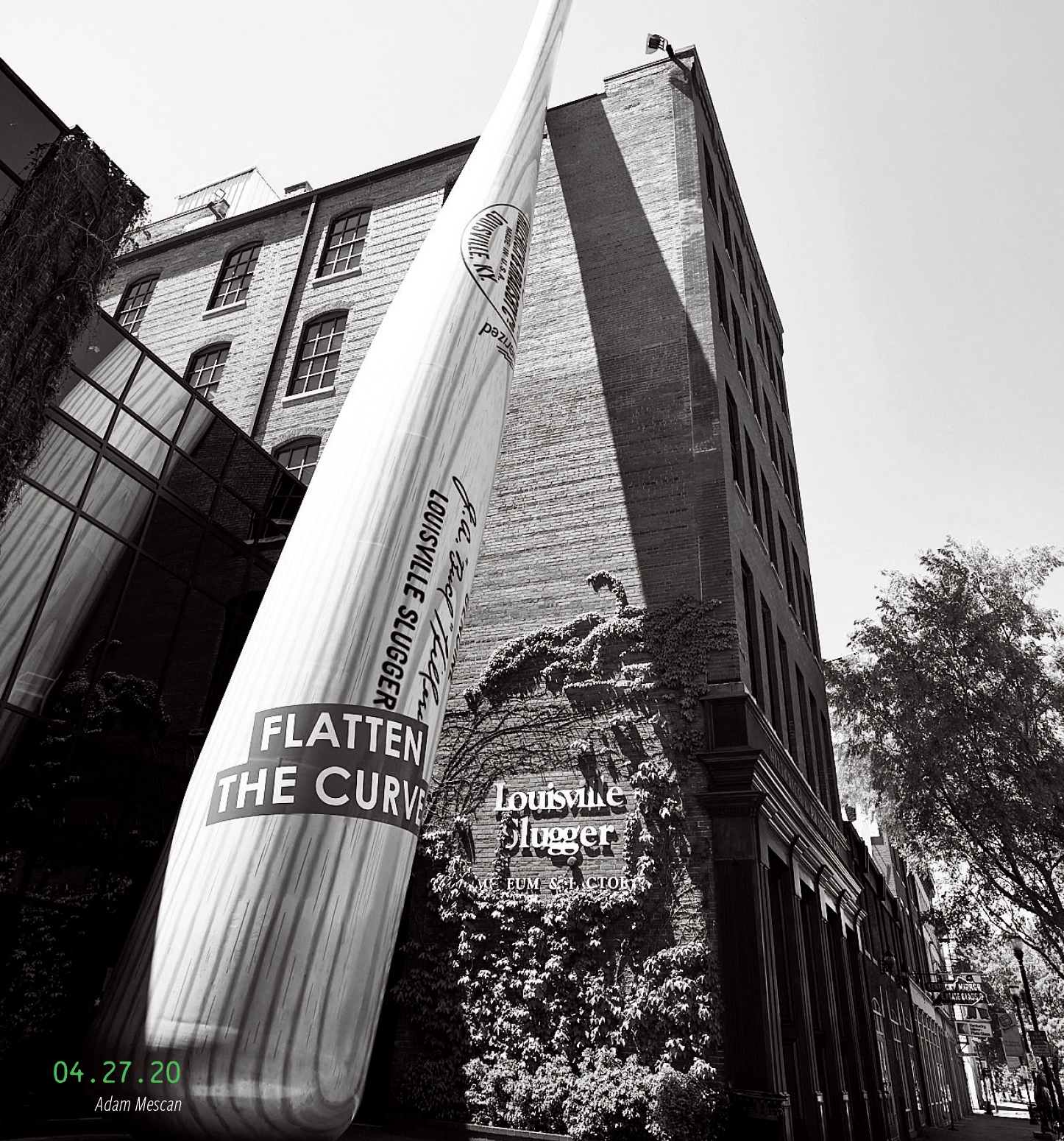 The bat outside Louisville Slugger Museum, with a sign reading, "Flatten the curve." 04.27.2020, by Adam Mescan